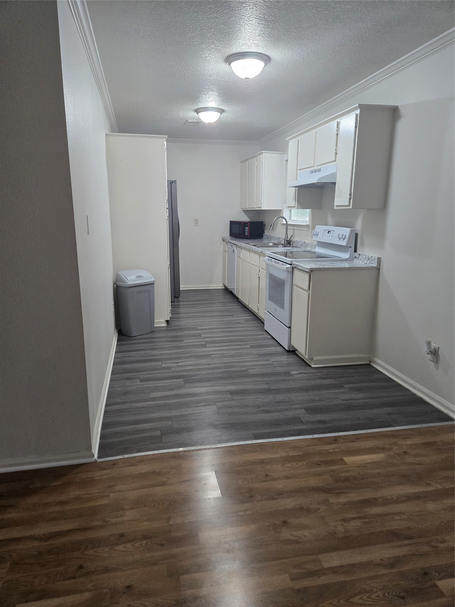 4215 Ross Avenue Bacliff, TX 77518 - Photo 5 of 14 a large kitchen with cabinets wooden floor and stainless steel appliances