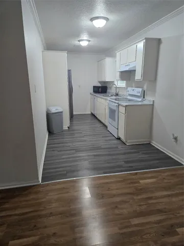 a large kitchen with cabinets wooden floor and stainless steel appliances