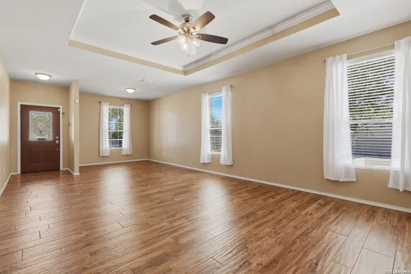 a view of an empty room with a window and wooden floor