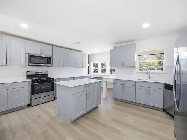 a kitchen with a sink cabinets and stainless steel appliances