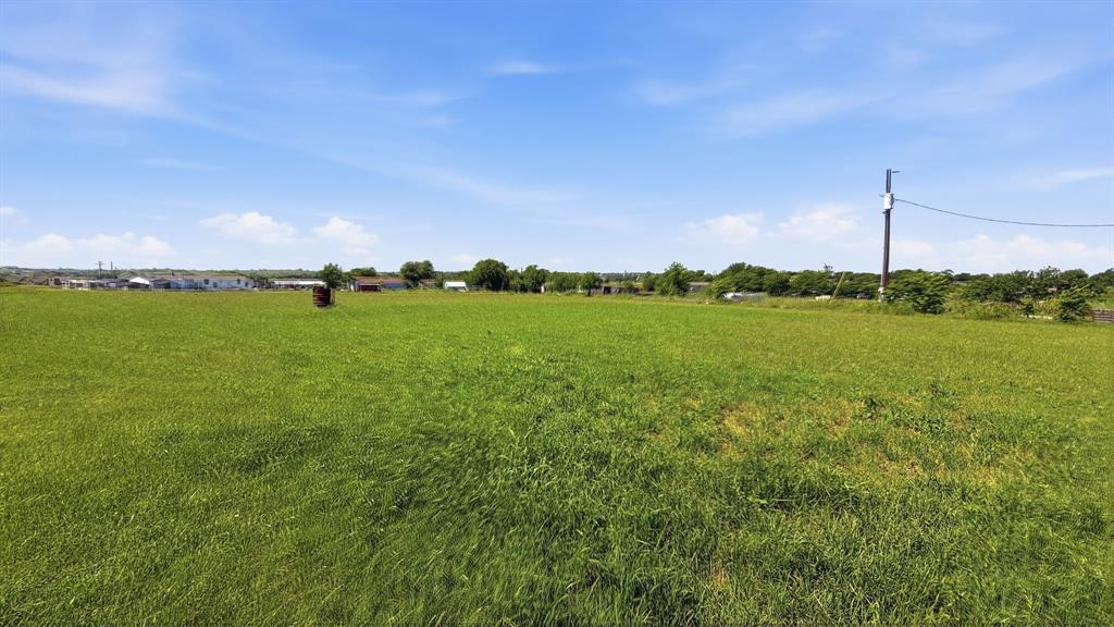 185 Private Road 4437 Rhome, TX 76078 - Photo 23 of 28 Expansive green field under a clear blue sky