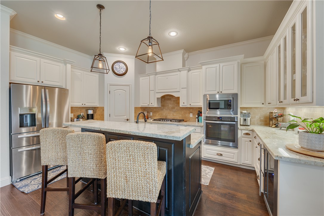 3301 Covington Court Bryan, TX 77808 - Photo 7 of 26 a kitchen with stainless steel appliances granite countertop a stove a sink a stove a refrigerator cabinets and a refrigerator
