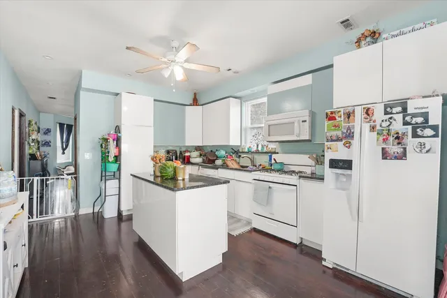 a kitchen with white cabinets and white appliances