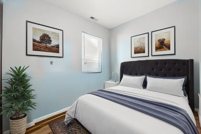 a bedroom with bed and wall painting with wooden floor