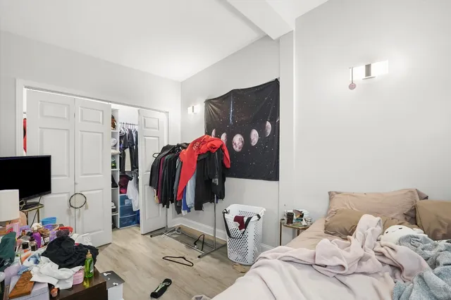 a view of a bedroom with a bed and a window