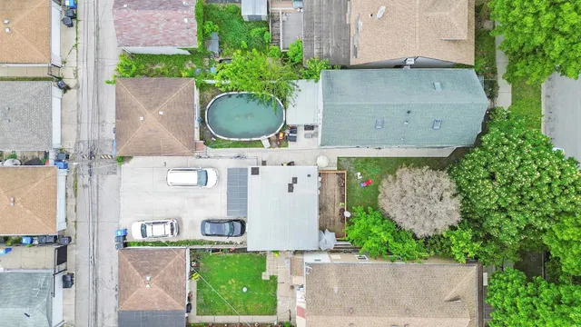 an aerial view of a house with garden space and a car parked