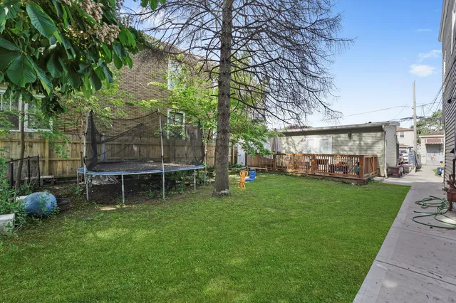 a view of a house with backyard and a tree