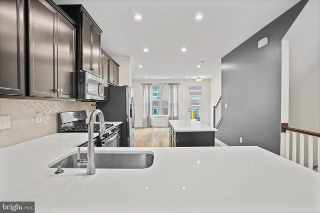 a kitchen with stainless steel appliances a sink a stove and a refrigerator