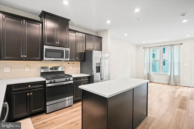 a kitchen with granite countertop stainless steel appliances cabinets a sink and a counter space