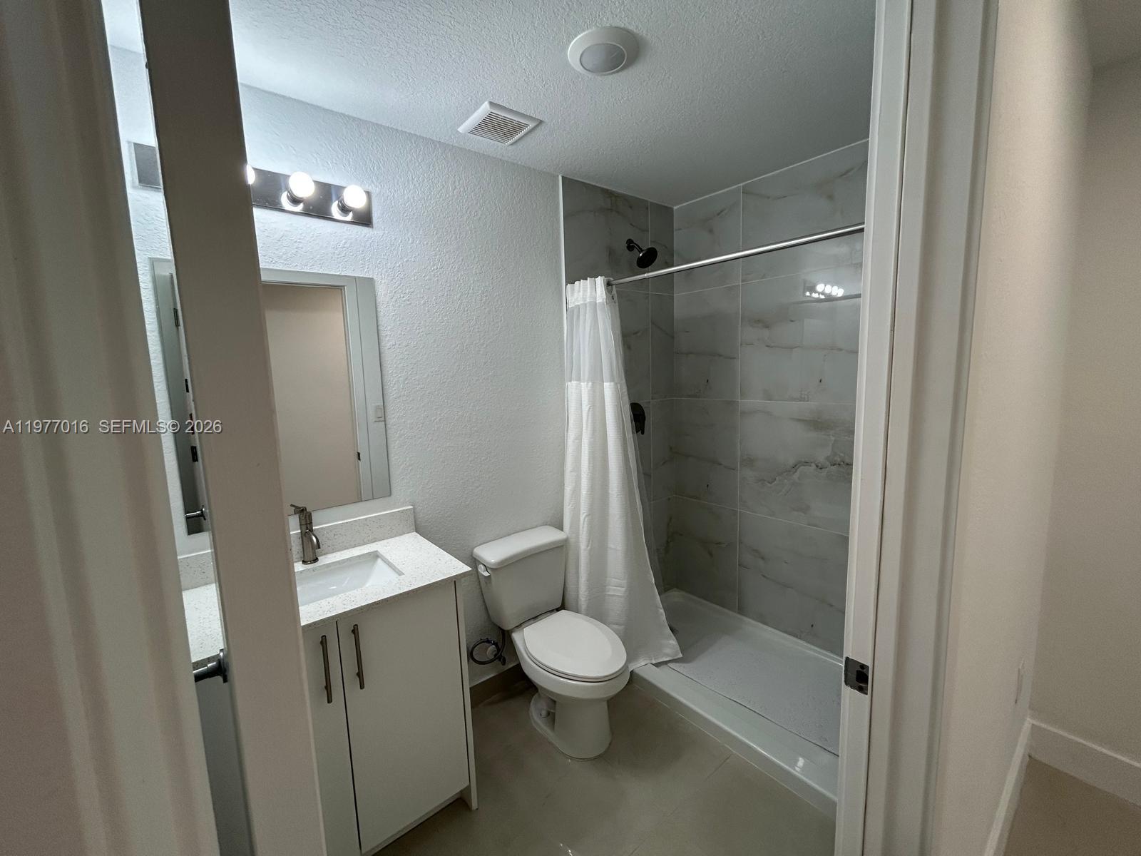 25814 Southwest 144th Court, Unit 2 Homestead, FL 33032 - Photo 11 of 25 a bathroom with a shower a toilet and a sink
