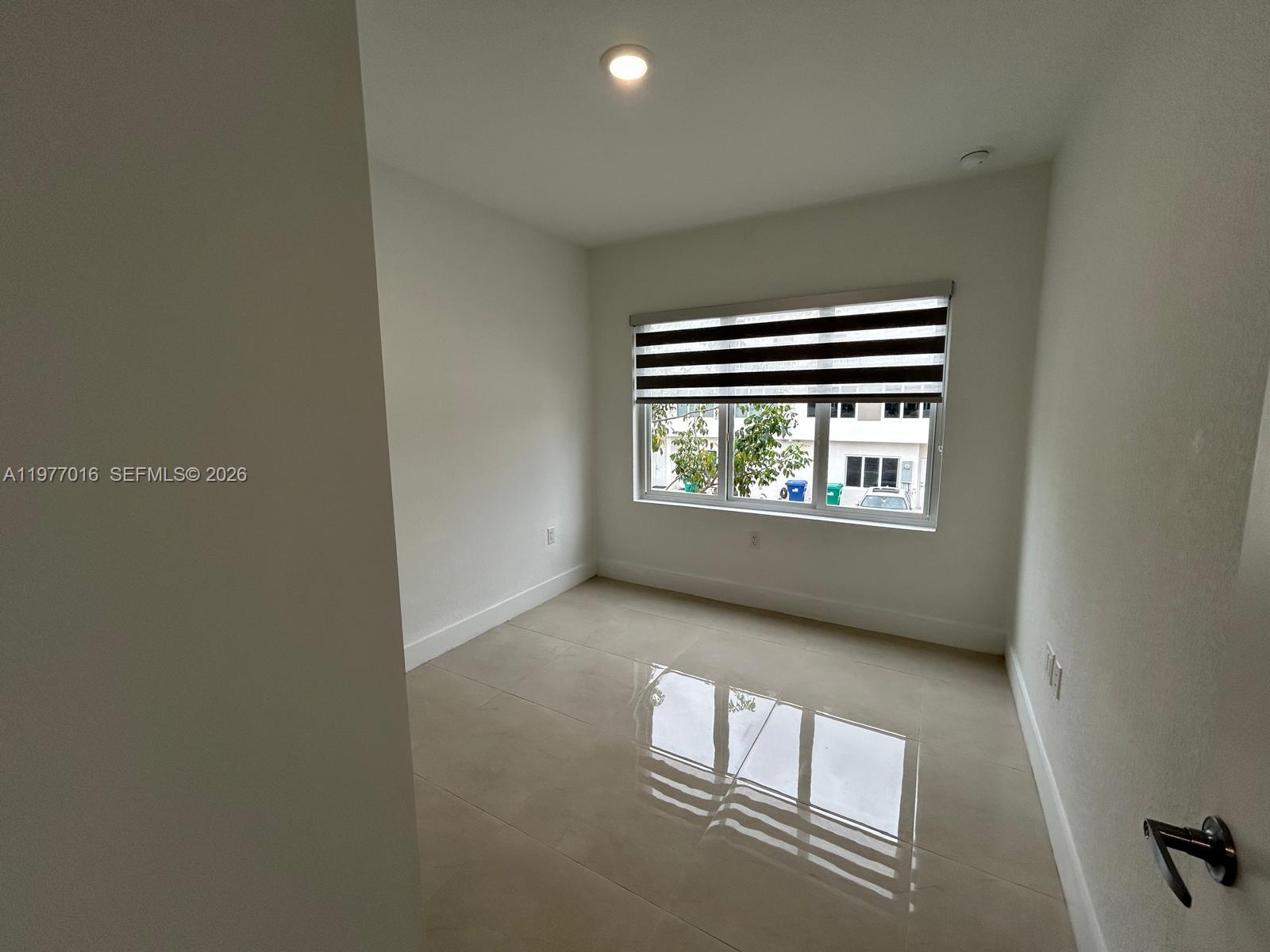25814 Southwest 144th Court, Unit 2 Homestead, FL 33032 - Photo 14 of 25 an empty room with windows