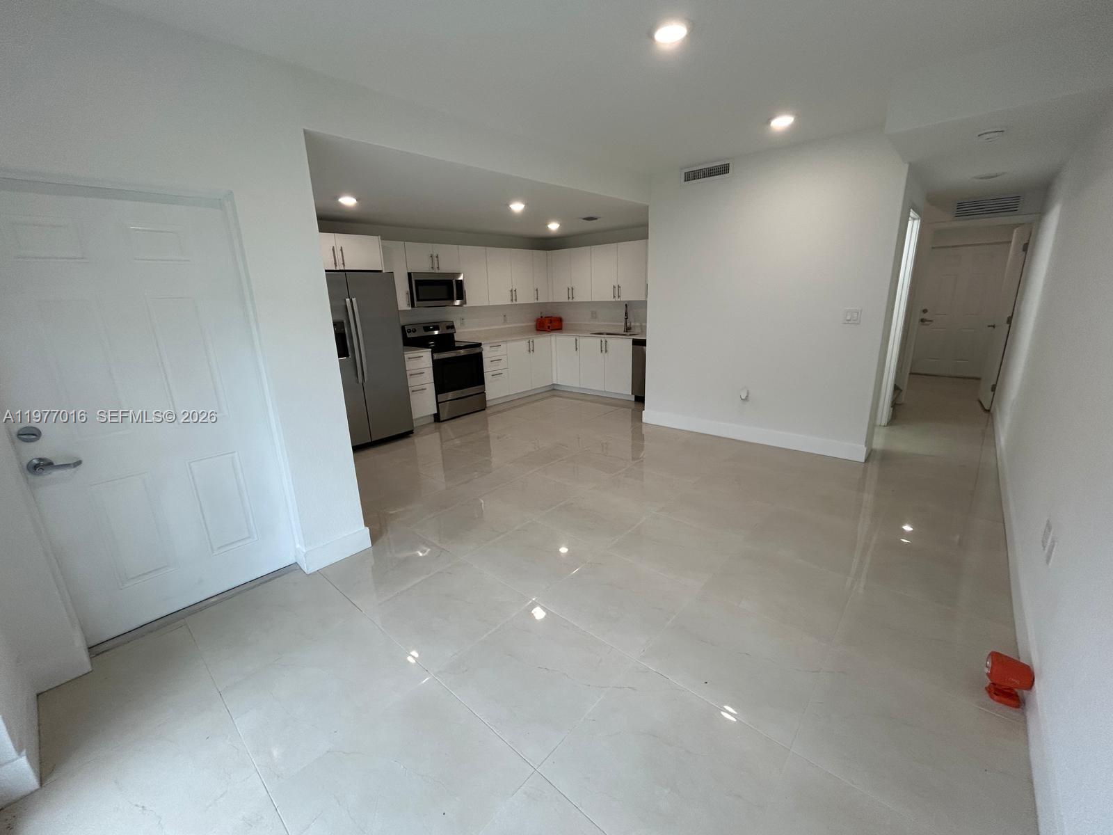 25814 Southwest 144th Court, Unit 2 Homestead, FL 33032 - Photo 3 of 25 a view of a kitchen with a sink and a refrigerator