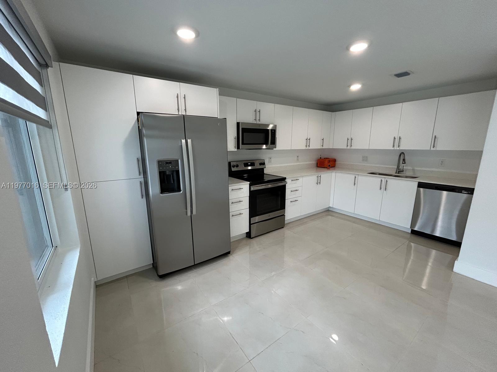 25814 Southwest 144th Court, Unit 2 Homestead, FL 33032 - Photo 4 of 25 a kitchen with stainless steel appliances a refrigerator and a stove top oven