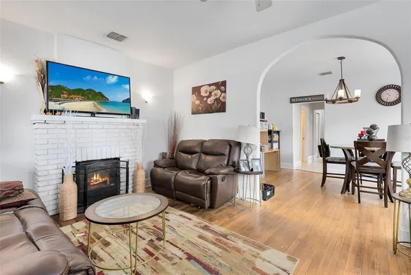 a living room with furniture a fireplace and kitchen view