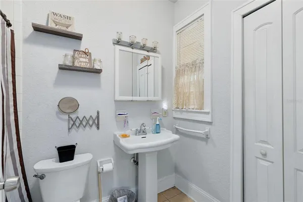 a bathroom with a sink a toilet and mirror