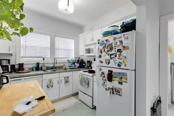 a kitchen with stainless steel appliances a sink a window and cabinets