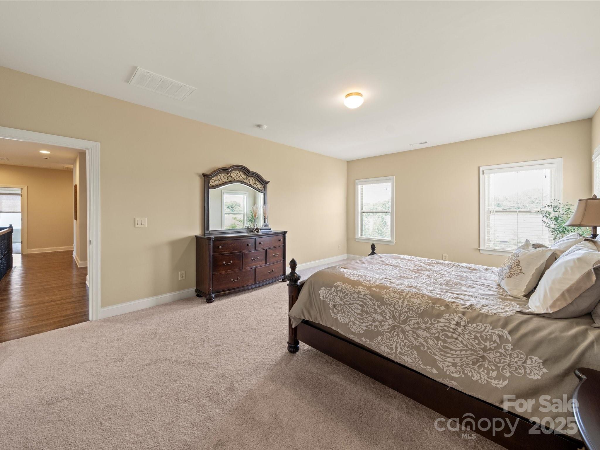 11632 Barnard Street Mint Hill, NC 28227 - Photo 25 of 39 a spacious bedroom with a bed and wooden floor