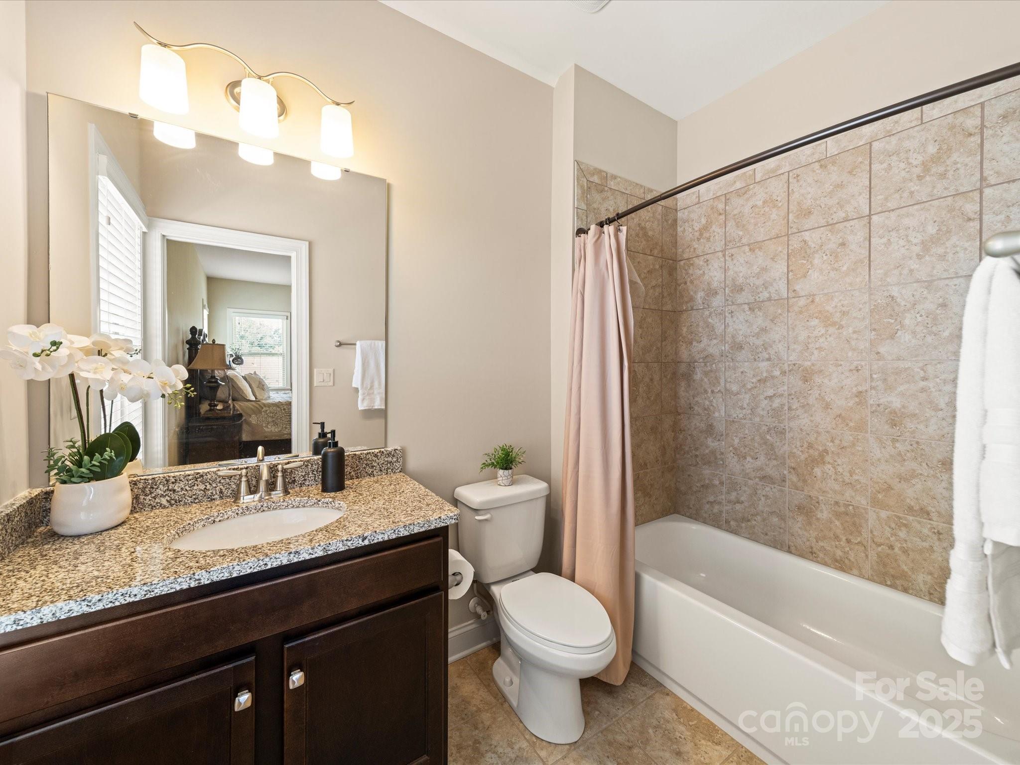 11632 Barnard Street Mint Hill, NC 28227 - Photo 26 of 39 a bathroom with a granite countertop sink a toilet and shower