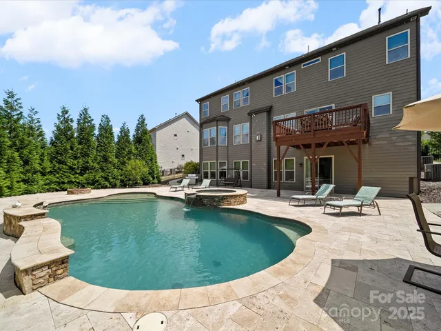 a view of a swimming pool with a yard and plants