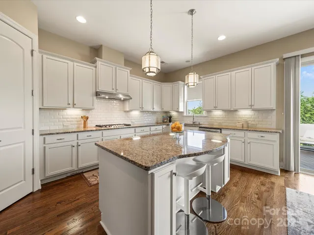 a kitchen with stainless steel appliances granite countertop a sink refrigerator and cabinets