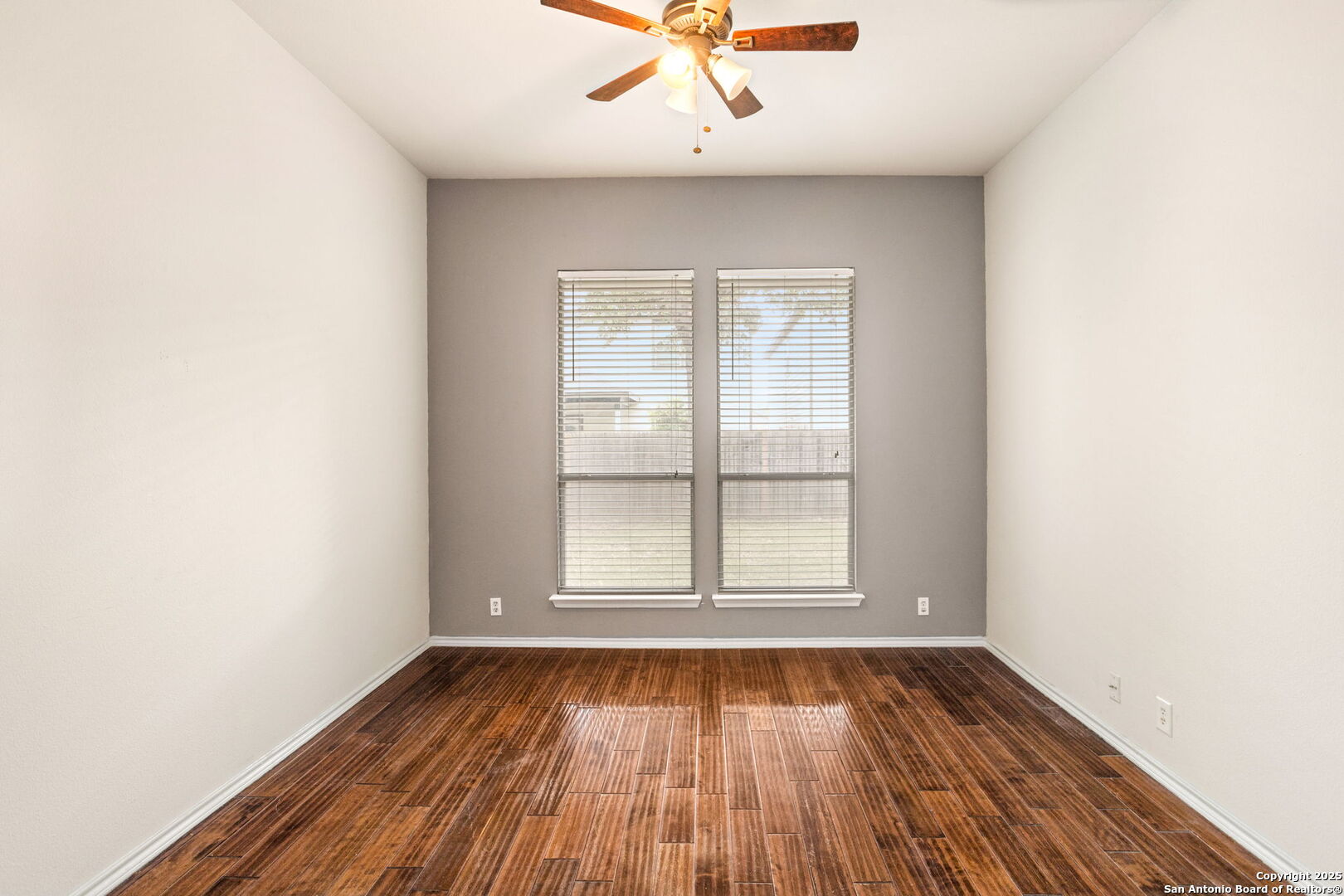 6737 Terra Rye San Antonio, TX 78240 - Photo 5 of 26 an empty room with wooden floor and windows