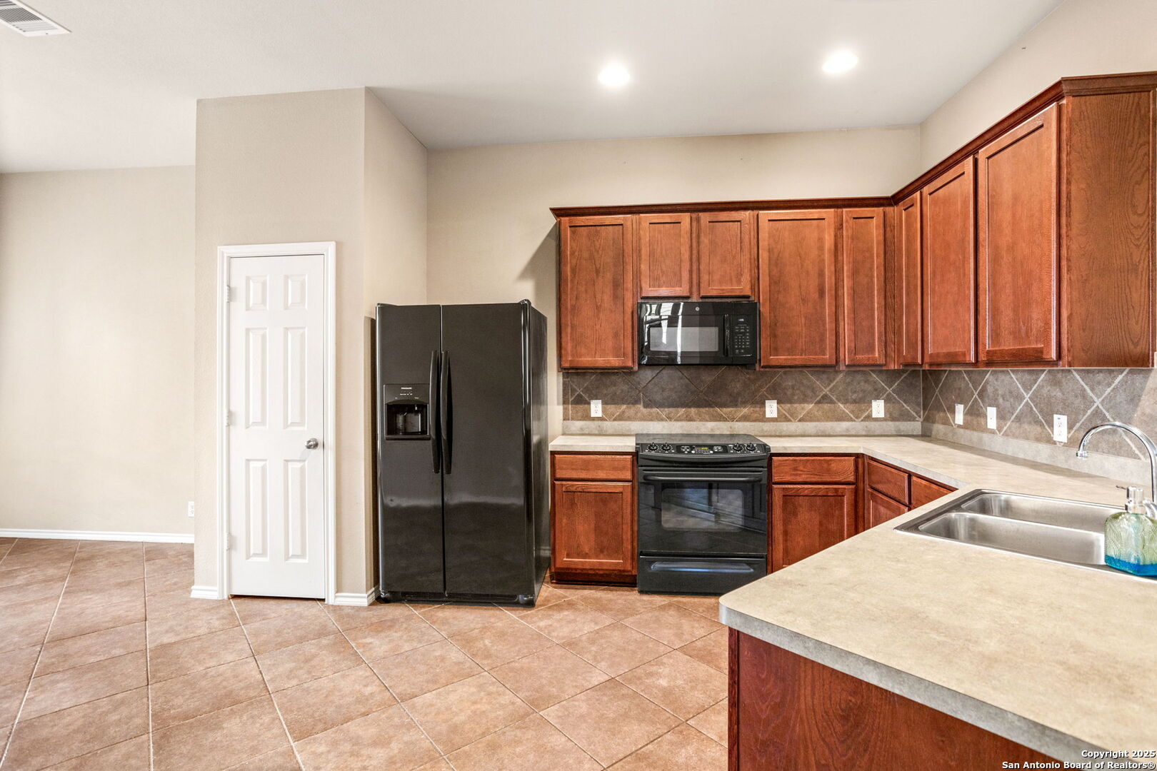 6737 Terra Rye San Antonio, TX 78240 - Photo 7 of 26 a kitchen with stainless steel appliances granite countertop a refrigerator stove and sink
