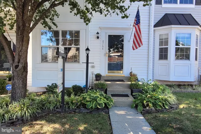 a front view of a house with a garden and plants