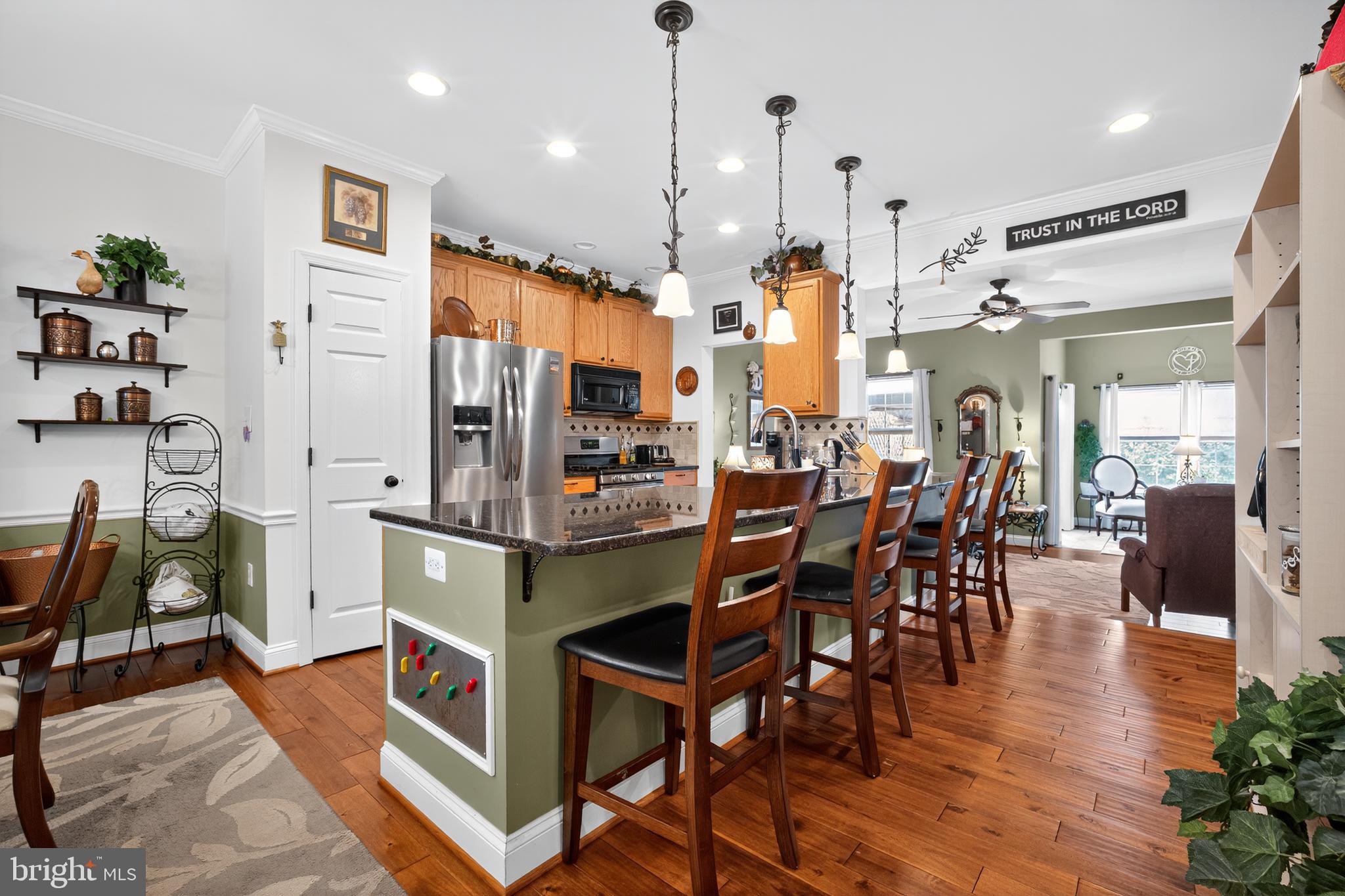 8768 Dunstable Loop Bristow, VA 20136 - Photo 6 of 47 a kitchen island with stainless steel appliances kitchen island granite countertop a table chairs and a stove