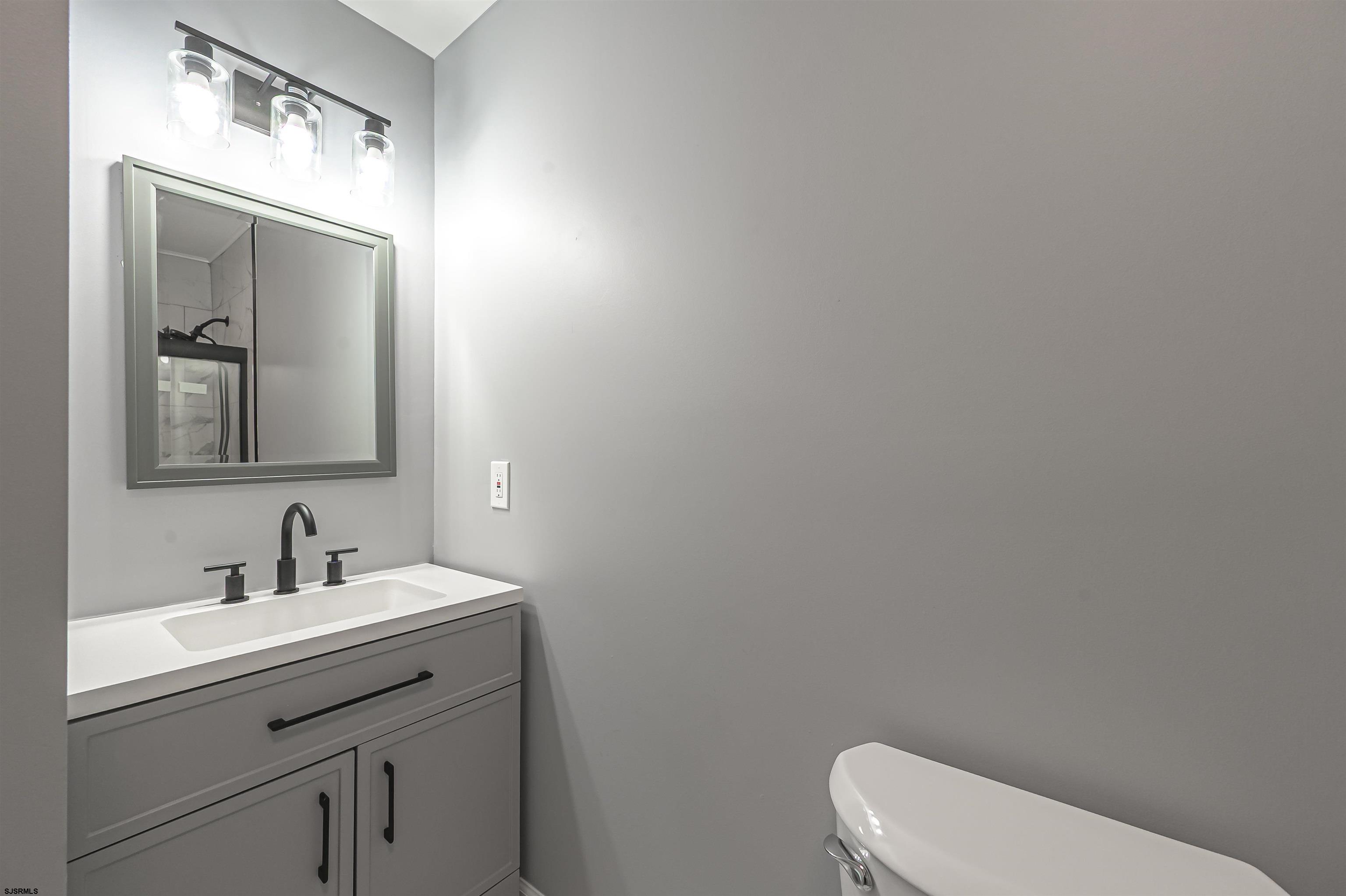 25 Robin Road Egg Harbor Township, NJ 08234 - Photo 11 of 24 a bathroom with a toilet a sink and mirror