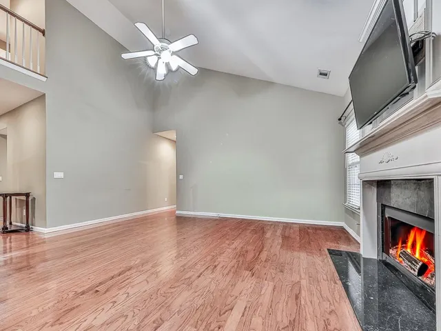 a view of an empty room with window and wooden floor