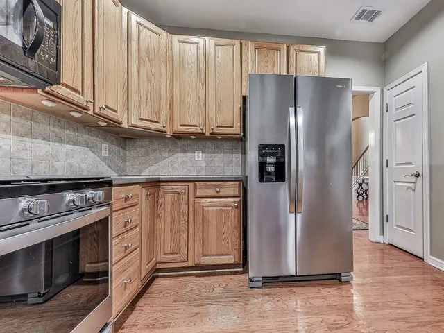 a kitchen with stainless steel appliances granite countertop a refrigerator stove and cabinets