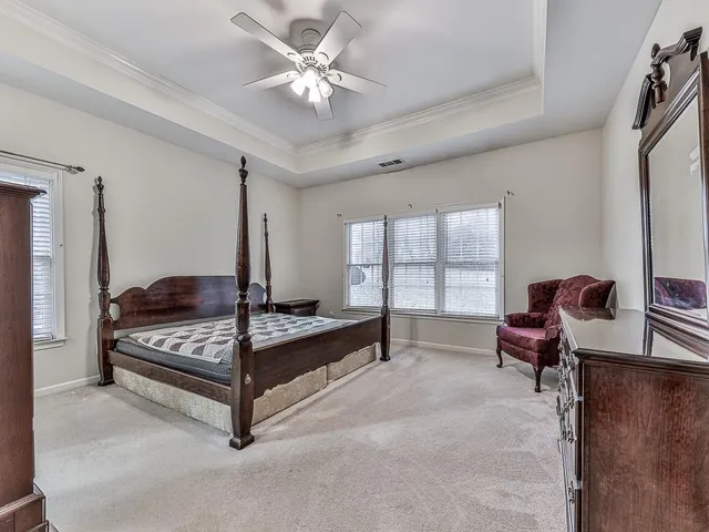a spacious bedroom with a bed and a chandelier