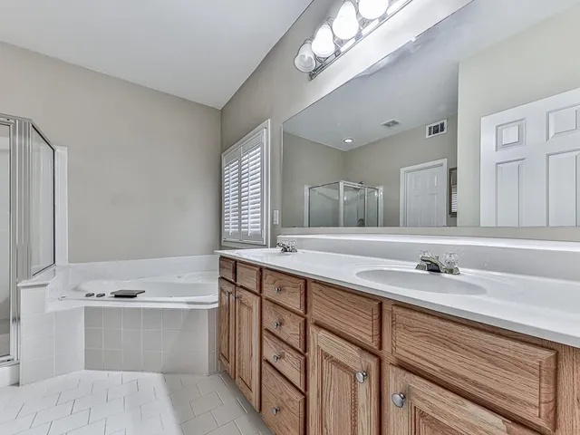 a bathroom with a sink a large mirror and a bathtub