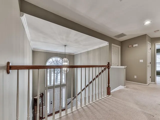a view of staircase with railing and white walls