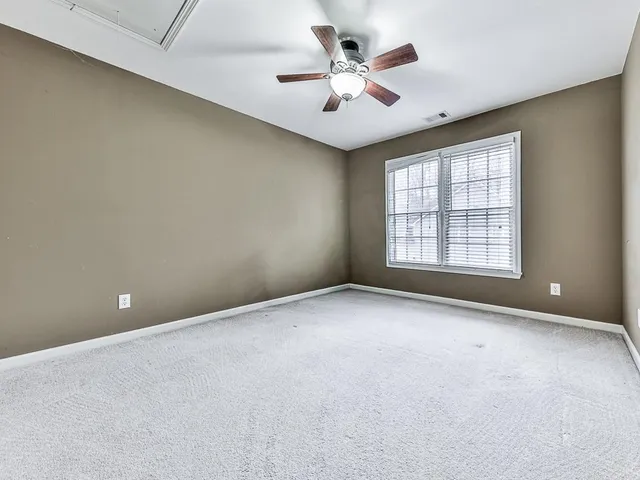 an empty room with windows and ceiling fan