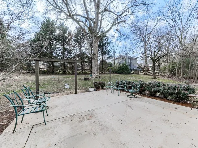 a view of a patio with a table and chairs and a large tree