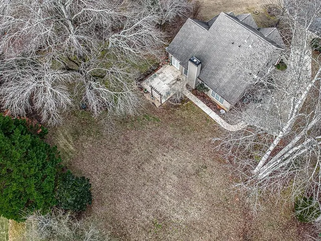 a front view of a house with a garden and trees