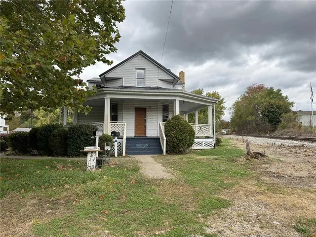 a view of a house with a yard and sitting area