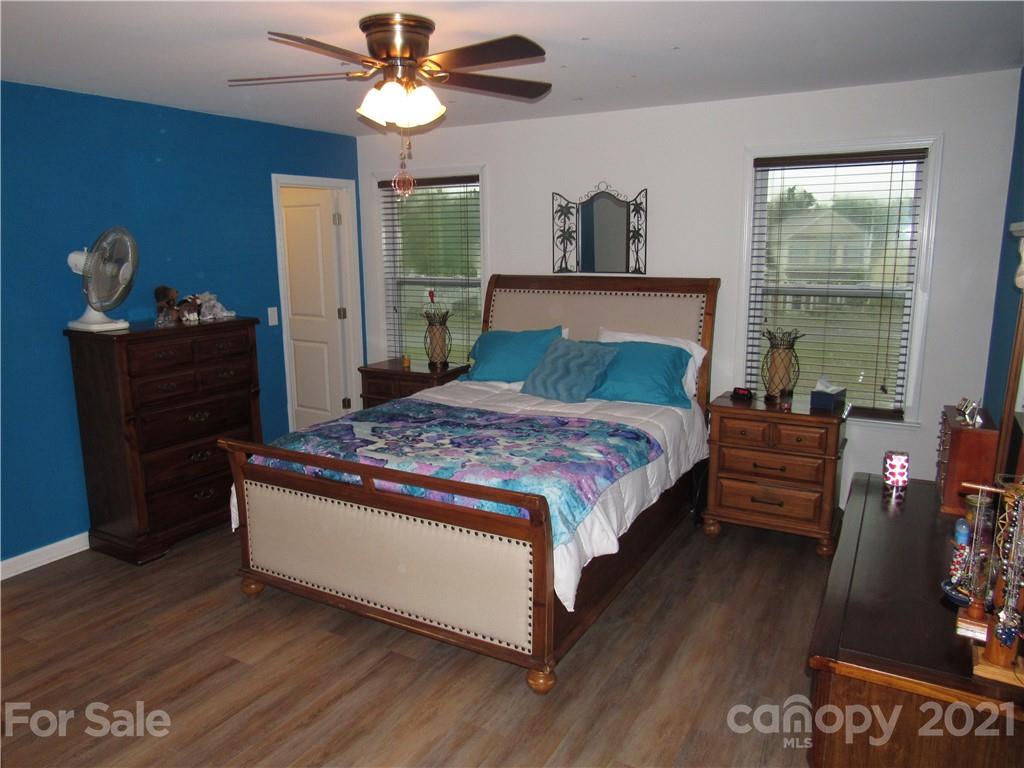 8188 Thornton Street Locust, NC 28097 - Photo 13 of 36 a bedroom with a bed and a chandelier