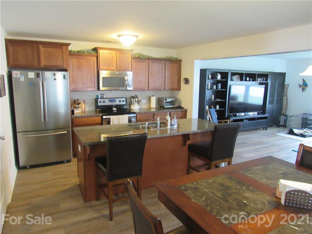 8188 Thornton Street Locust, NC 28097 - Photo 17 of 36 a kitchen with a table chairs refrigerator and couch
