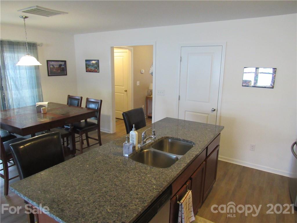 8188 Thornton Street Locust, NC 28097 - Photo 20 of 36 a kitchen with a stove a sink and a refrigerator