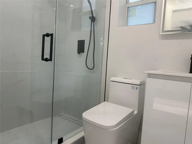 a bathroom with a toilet and a shower