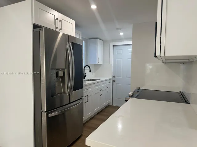 a kitchen with a refrigerator and a sink