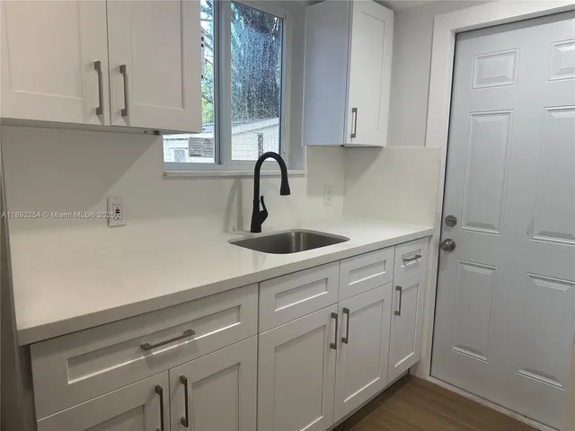 a kitchen with a sink cabinets and window