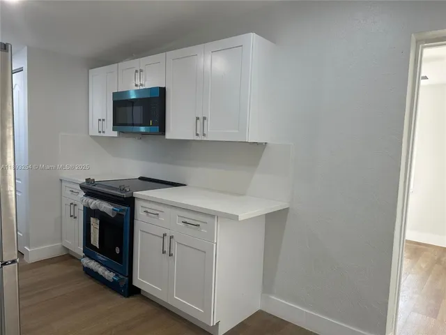 a kitchen with white cabinets and stainless steel appliances