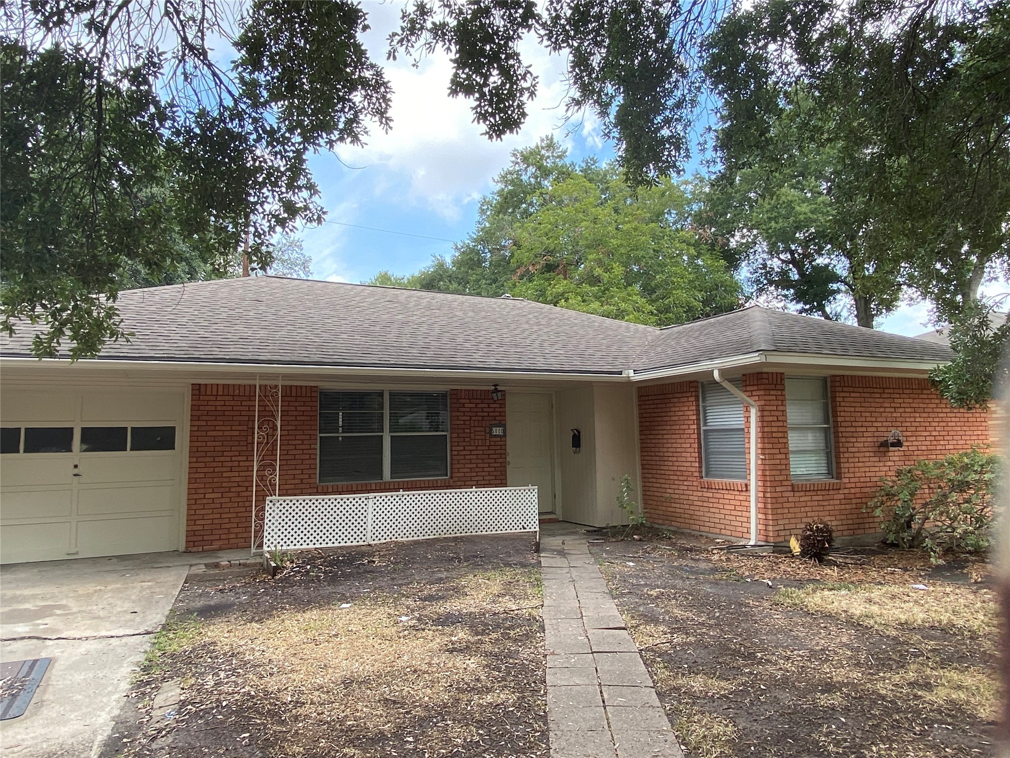 5110 West 43rd Street Houston, TX 77092 - Photo 1 of 14 a front view of a house with a garden and trees