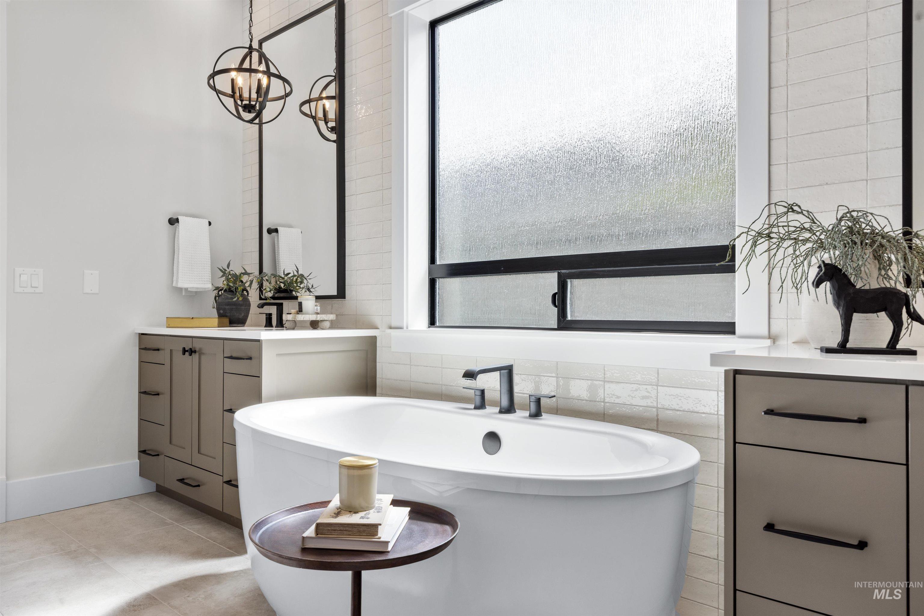 5940 South Pinpoint Way Meridian, ID 83642 - Photo 28 of 40 Freestanding soaking tub, dual vanity with integrated sinks, and individual mirrors