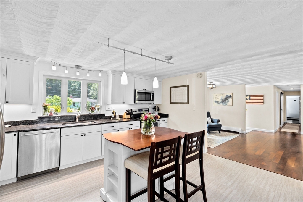 13 Pinewood Drive Framingham, MA 01701 - Photo 9 of 21 a kitchen with a dining table chairs cabinets and wooden floor
