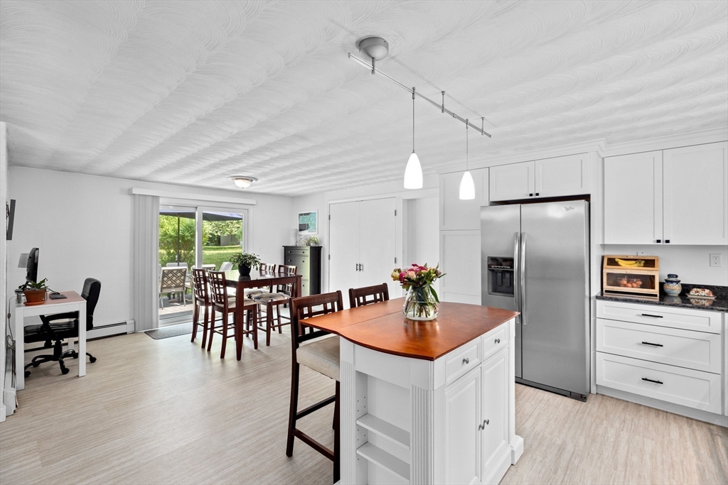 13 Pinewood Drive Framingham, MA 01701 - Photo 10 of 21 a kitchen with stainless steel appliances kitchen island granite countertop a table chairs and a refrigerator
