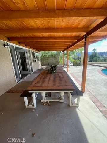 a view of a backyard with table and chairs under an umbrella